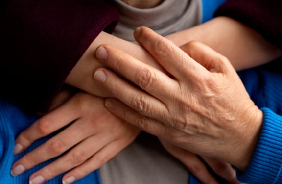 Woman putting her hands around her mother from behind